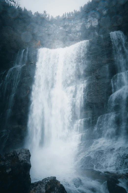 a waterfall in the wilderness on an overcast day