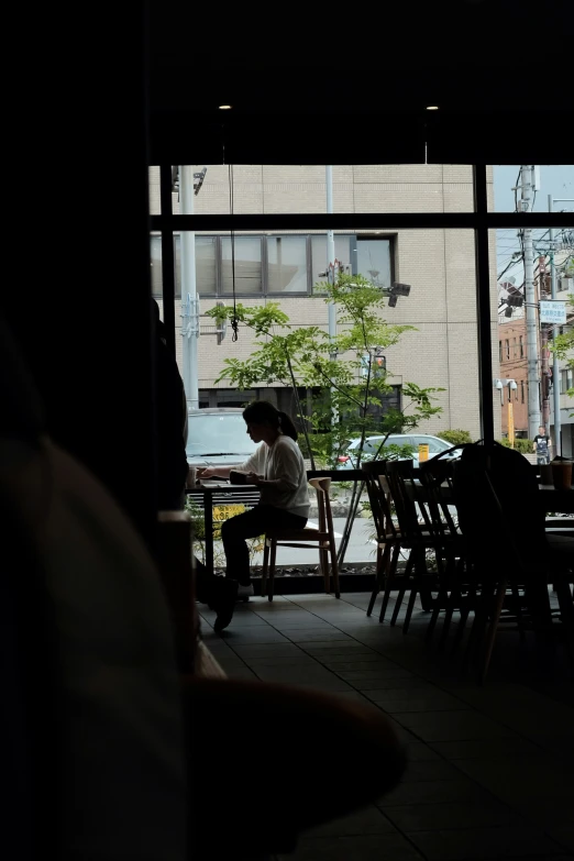 the silhouette of people at tables next to an open window