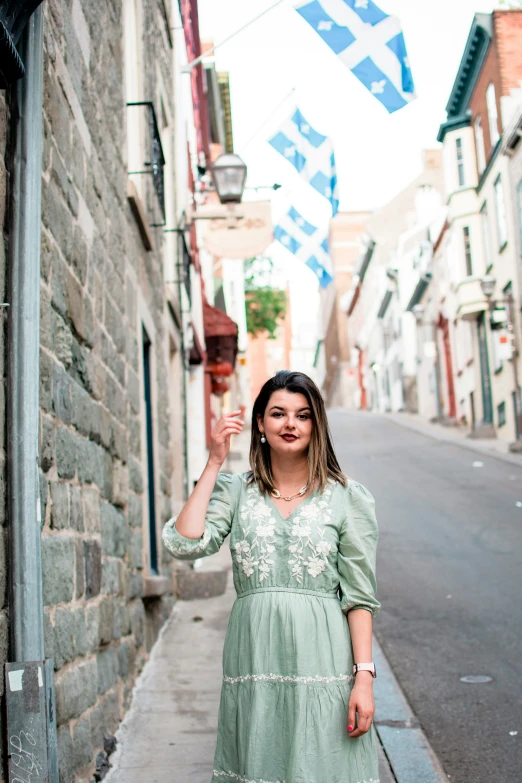 woman in green dress looking towards camera in urban area