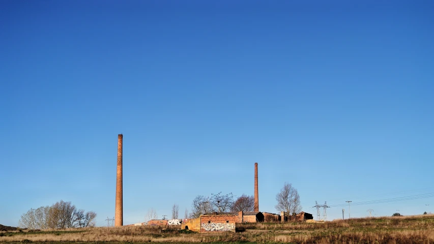 two tall chimneys are sitting in the distance