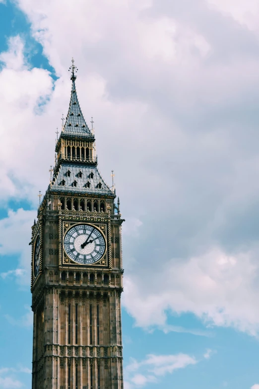 a tall clock tower under a cloudy blue sky