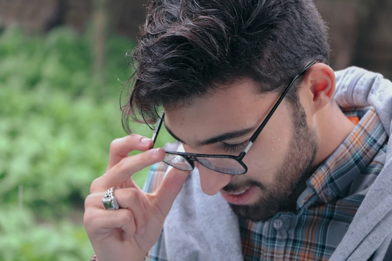 a man wearing glasses and a jacket talking on a cell phone