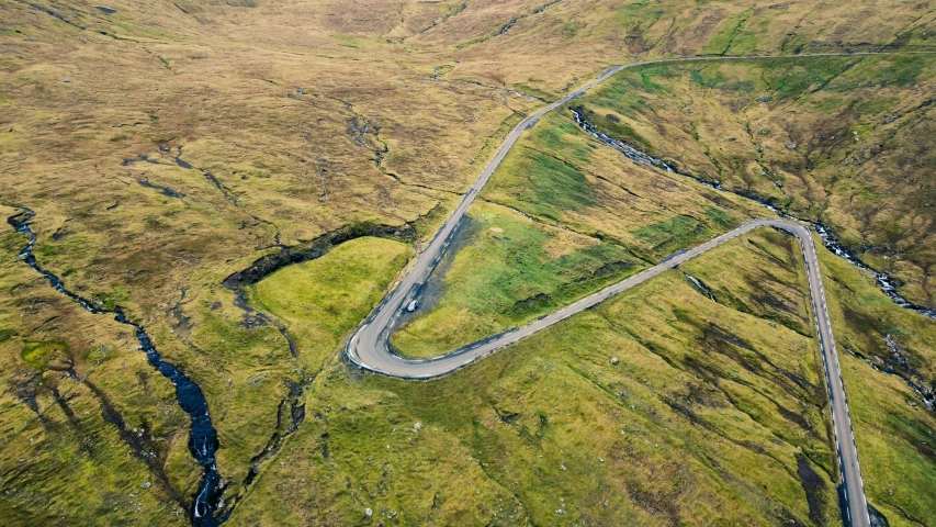 aerial view of the winding road with cars driving down it