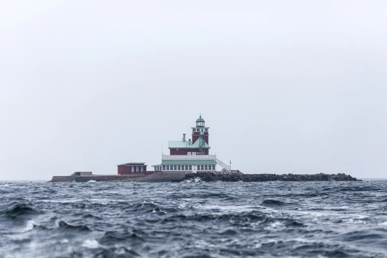 an ocean and island with a light tower on top