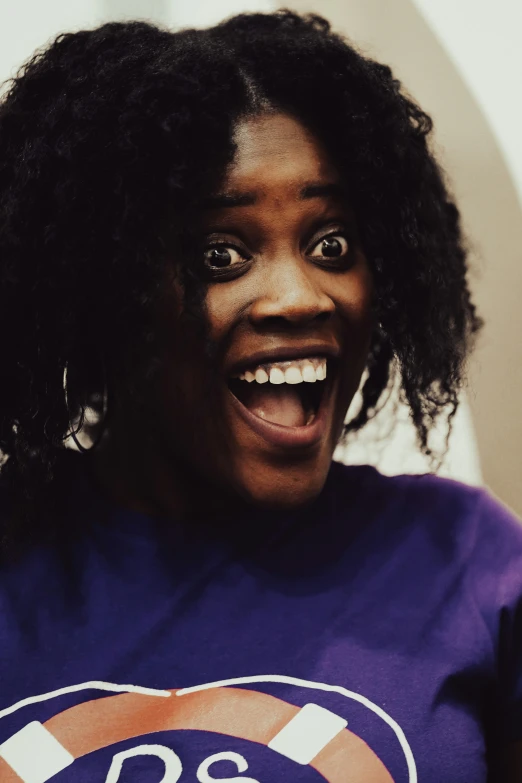 an afro woman with natural hair and purple shirt