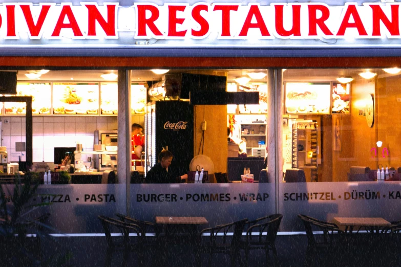 a restaurant is seen through the window at night