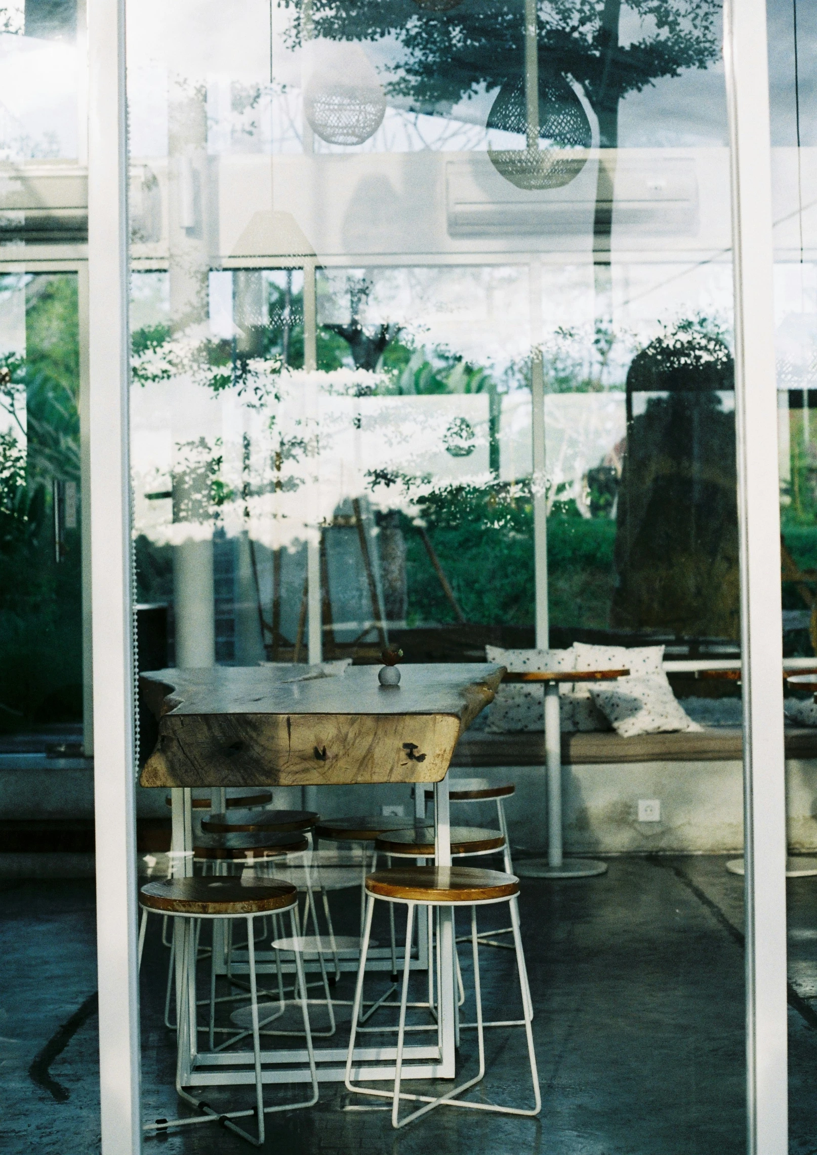 tables, chairs, and stools are visible through a glass door