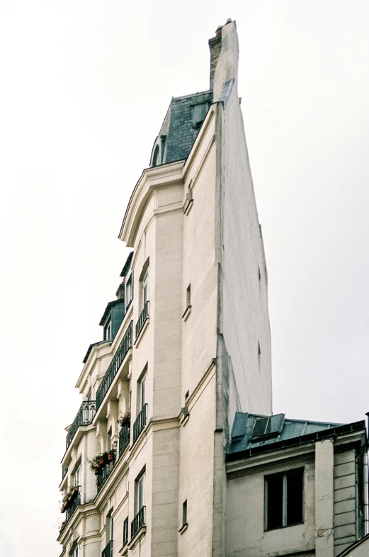 an old white building is in the midst of a grey sky