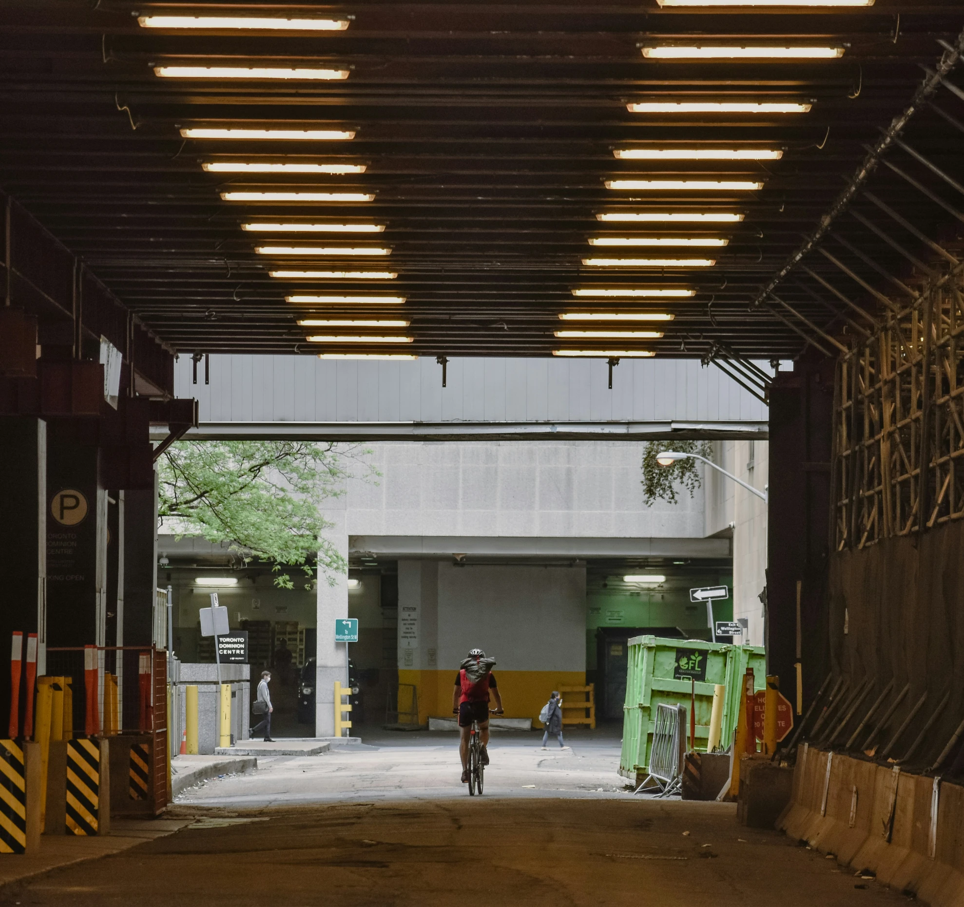 a person riding on a bike under a parking structure