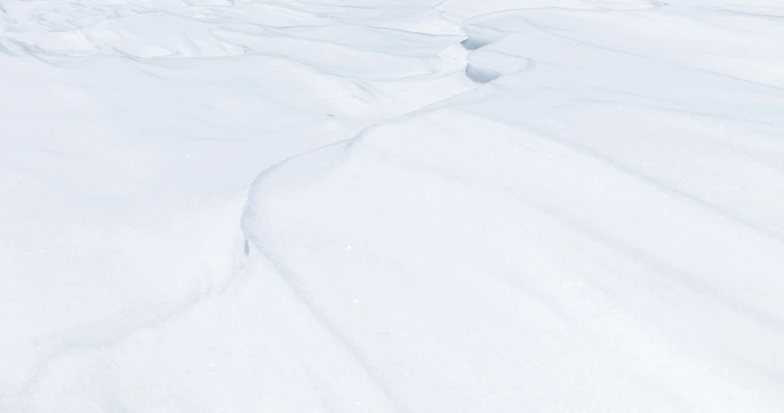 a man riding down the side of a snow covered slope