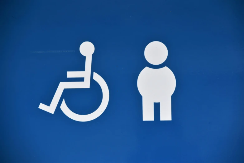 a blue sign with a white man in a wheelchair next to a handicapped symbol
