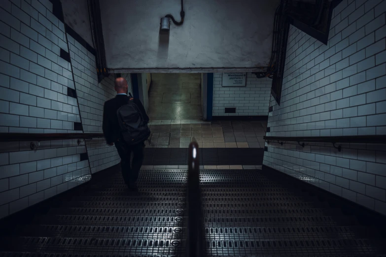 man with backpack walking down the stairs towards the toilet