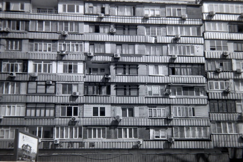 a black and white pograph of several windows in a building