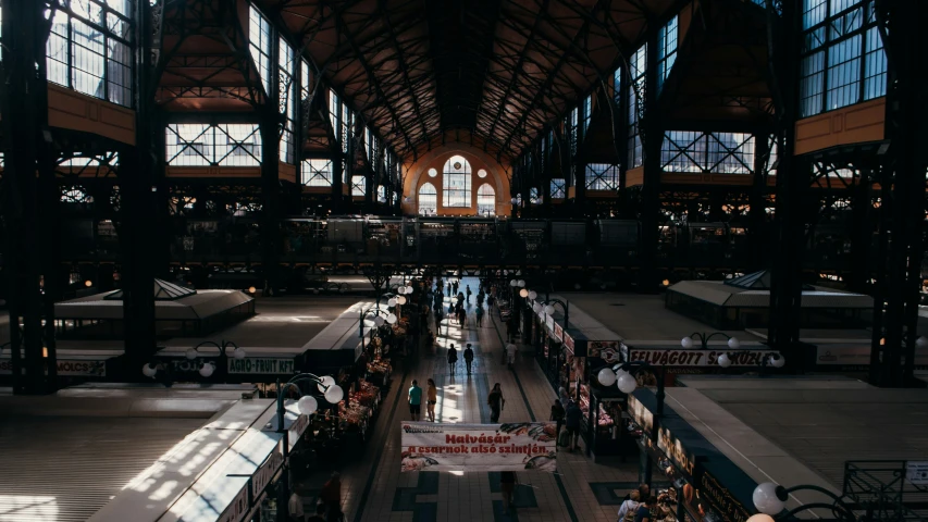 people walking around a large indoor mall filled with various stores