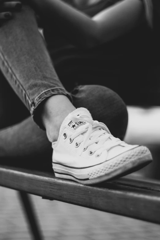 two pairs of legs and white shoes sitting on a table