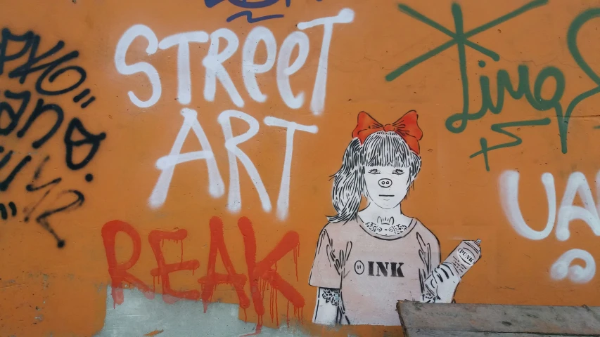 graffiti of an angry girl with her hand up to the side of a wall that has been painted orange