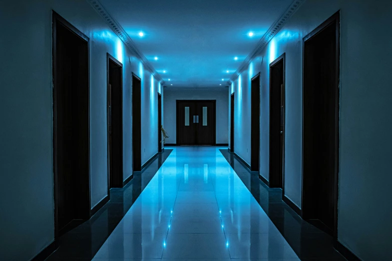 a long hallway in a large building lit up by blue lights