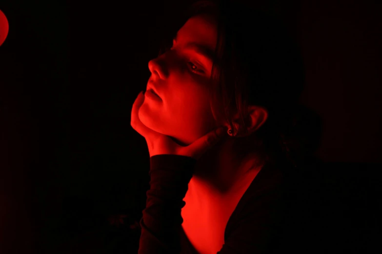 a woman in the dark looks off into the distance