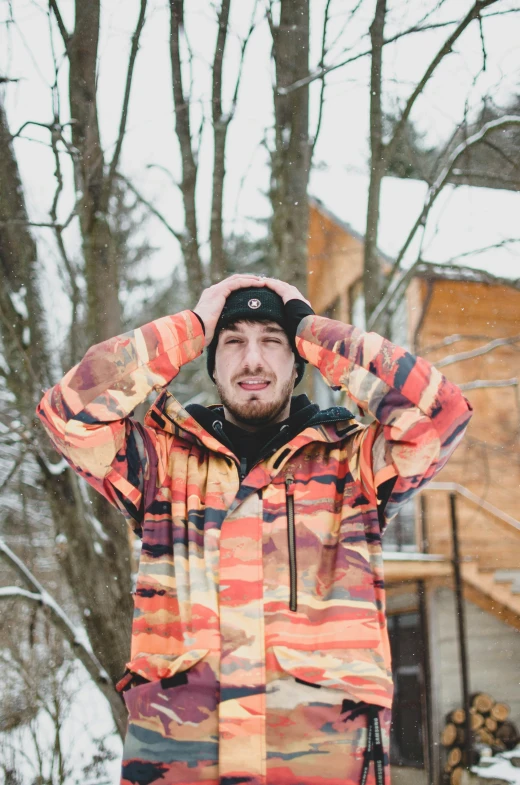 a man standing in the snow wearing a colorful jacket