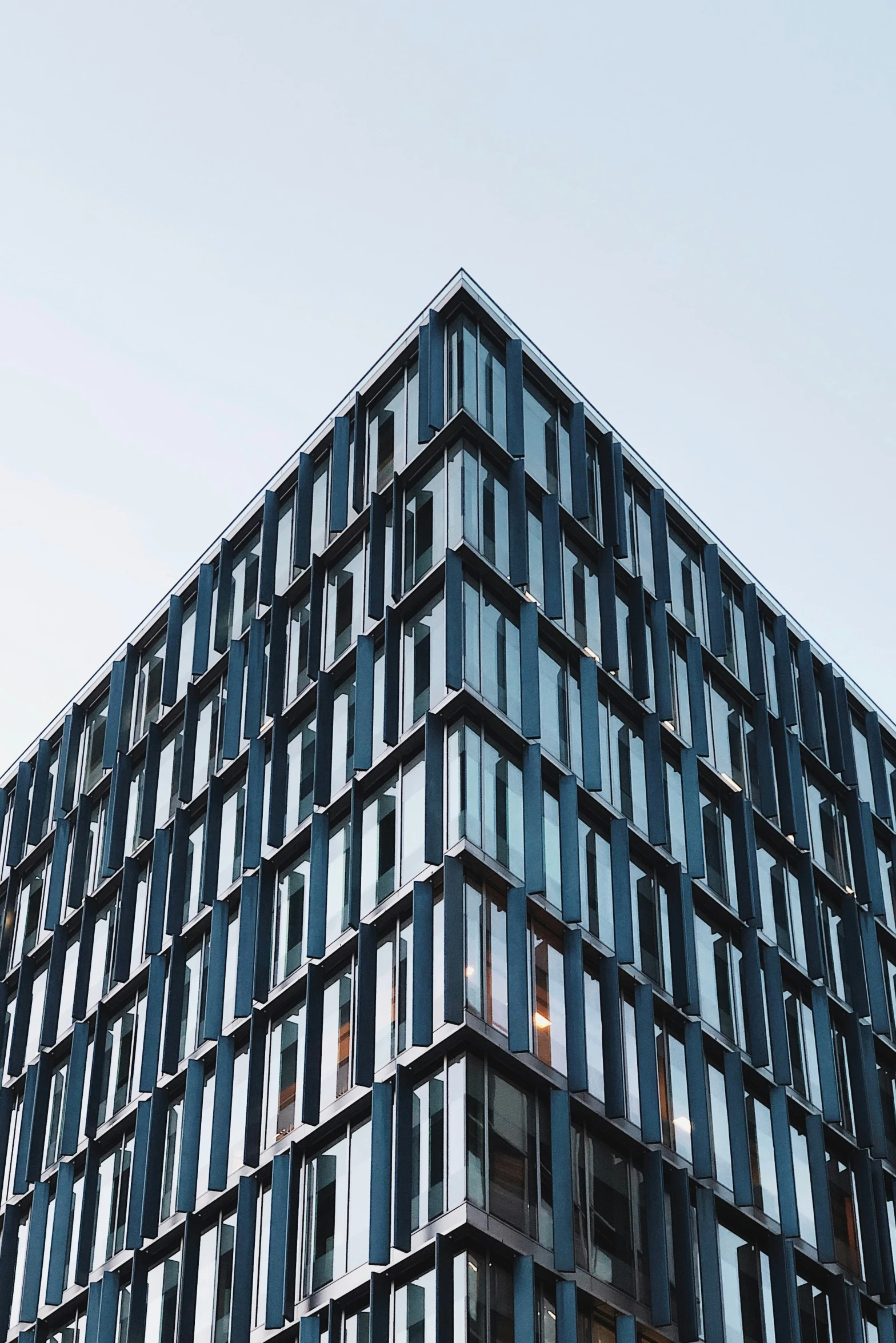 a large windowed building with sky in the background