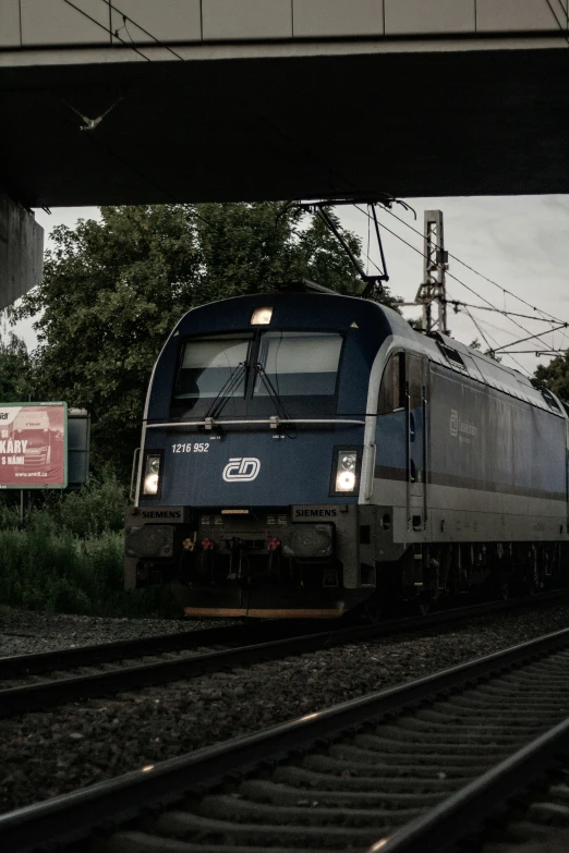 train moving across the track at station with another train approaching