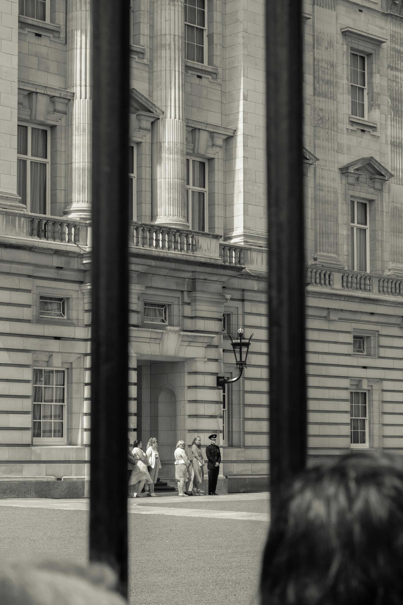 the old buildings with people walking out front are reflected in the windows of an iron bars