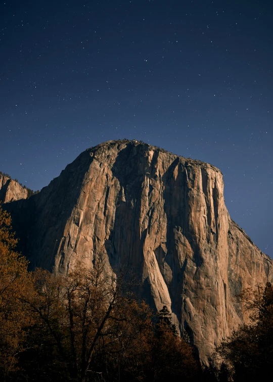 the full moon shines brightly behind mountains