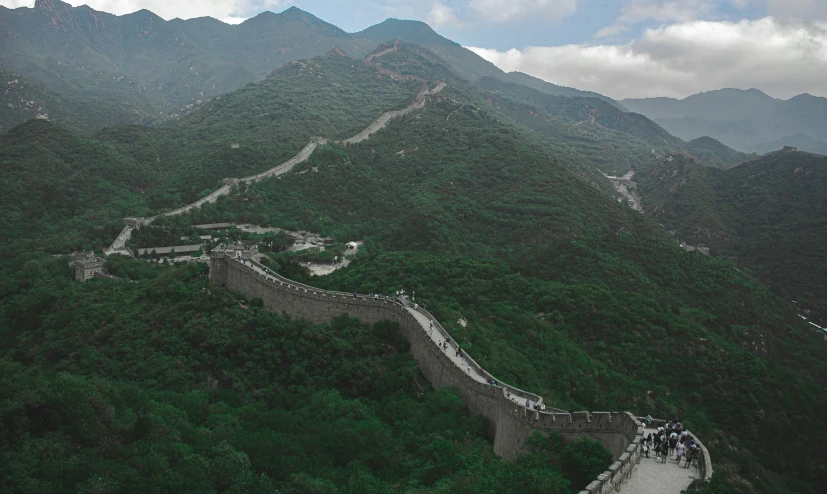 the great wall in china surrounded by lush green mountains