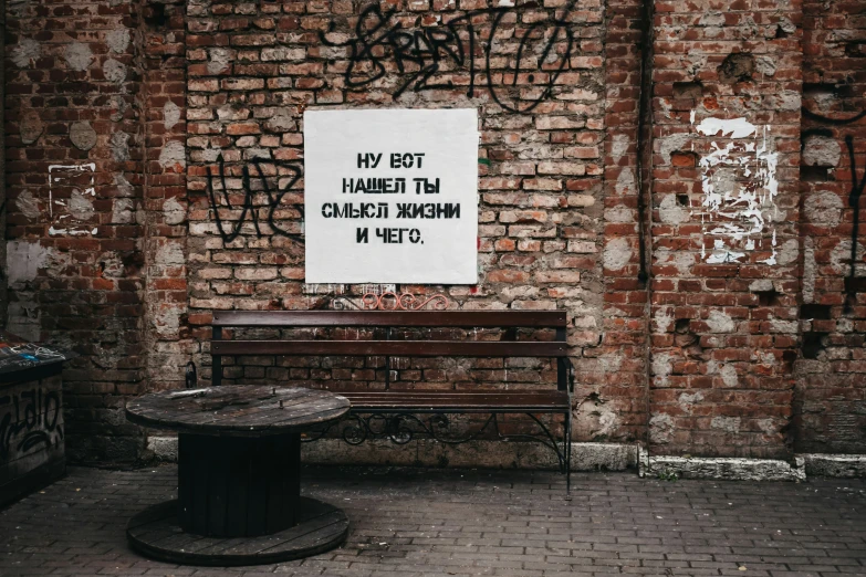 a bench with a graffiti covered wall behind it