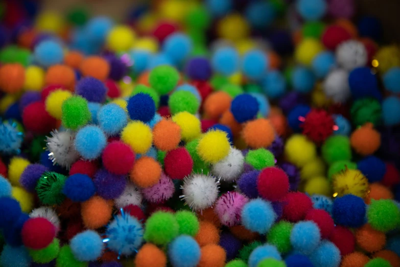 several colorful pom - poms, one has silver tips