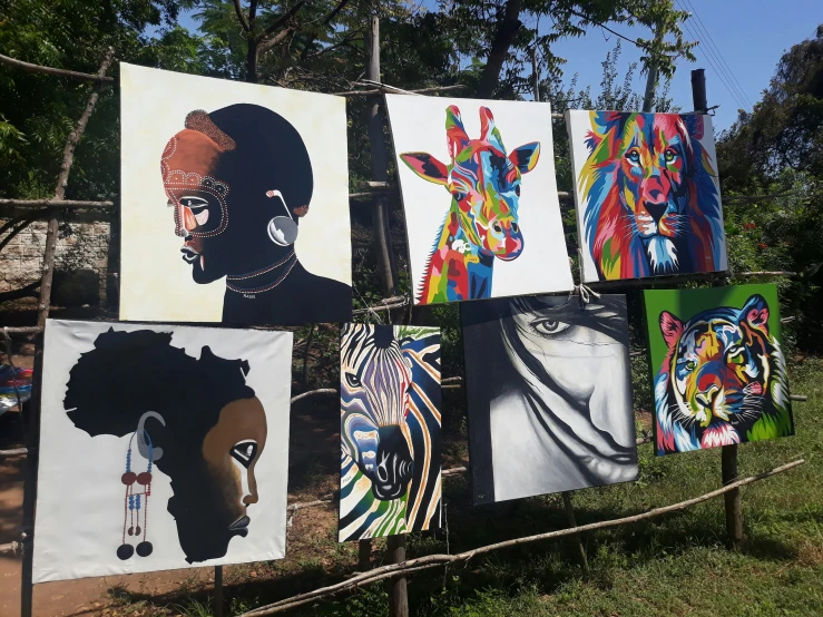 colorfully painted paintings hung on clothesline against a blue sky