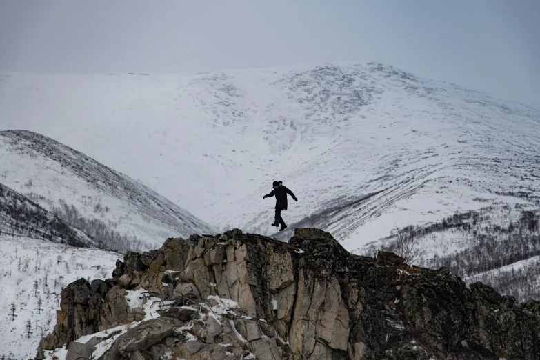 a man standing on top of a snow covered mountain