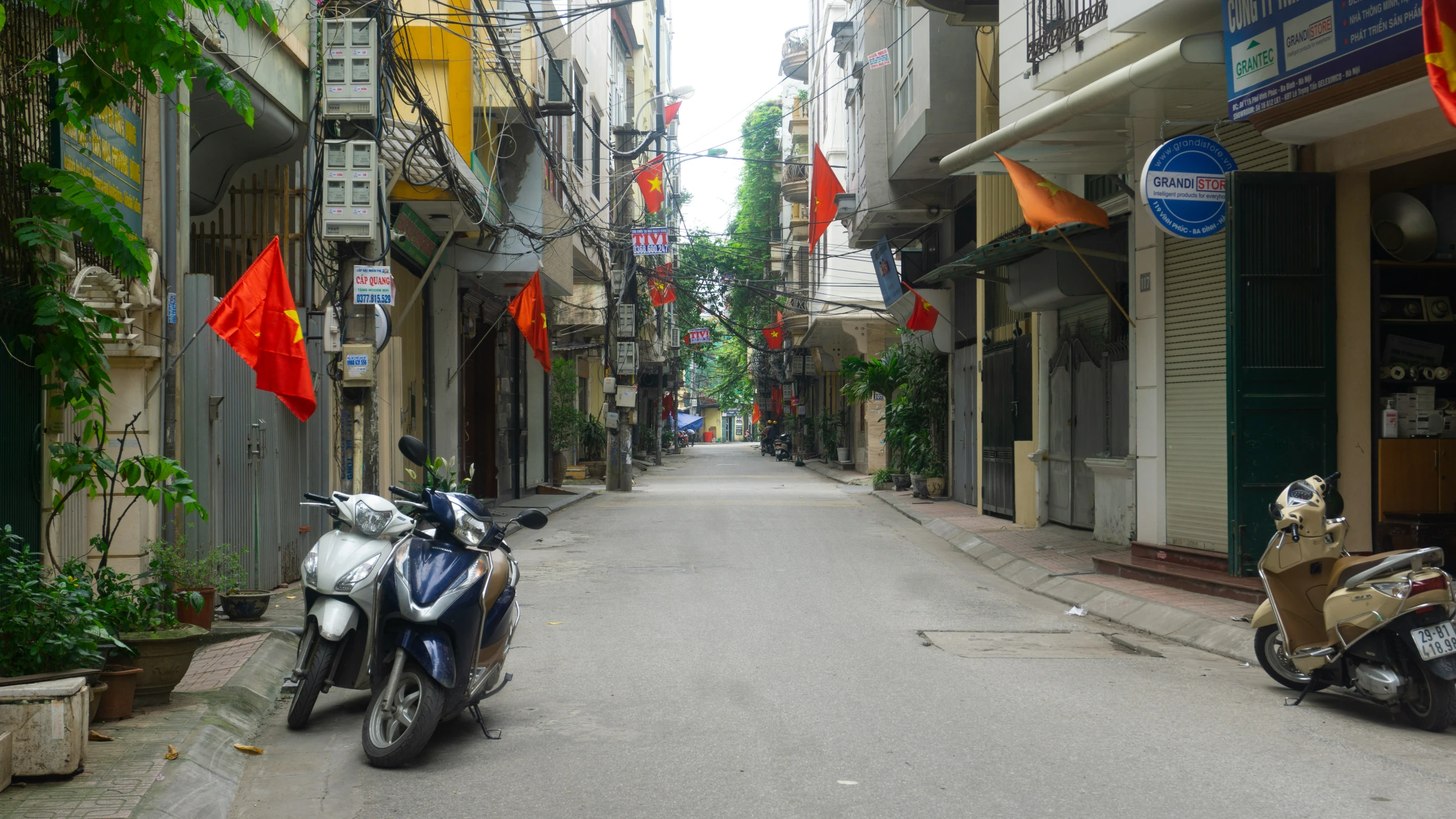 motorcycles parked outside an alleyway with flags