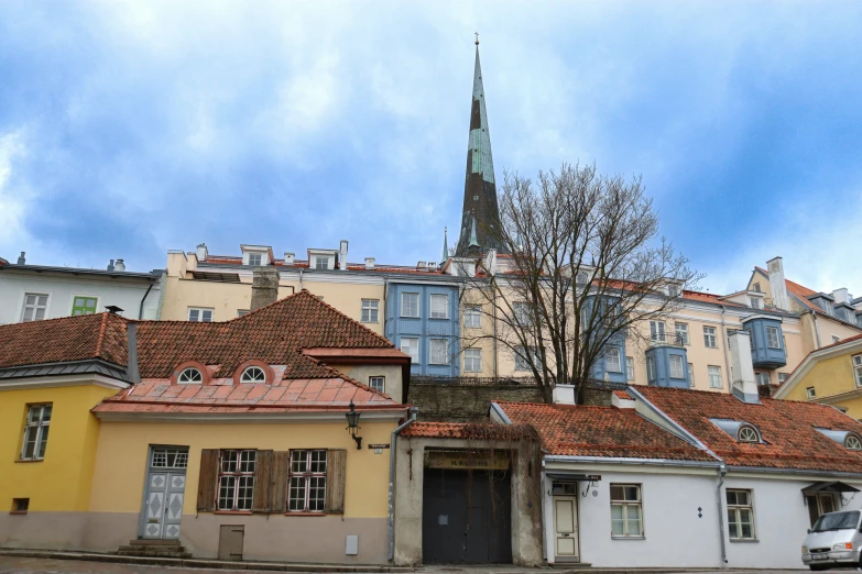 a church with a tall steeple stands in front of some buildings