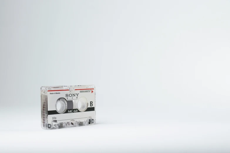 a white and black cassette with a silver design