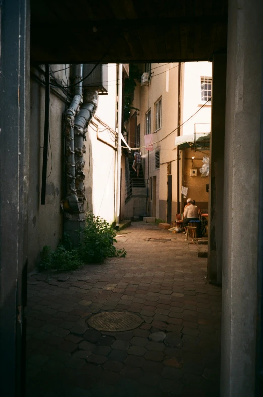 a view from the doorway to a couple of people sitting on a bench