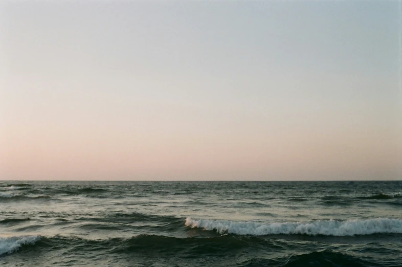 two people ride surfboards on a wave breaking