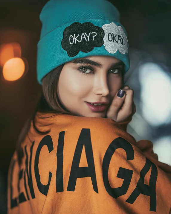 a girl wearing an orange chicago baseball jacket with a beanie