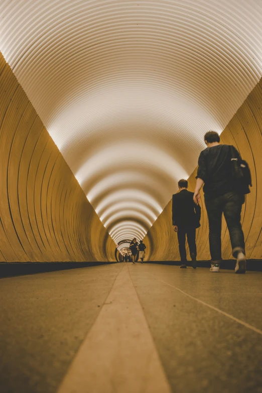 people walking through a tunnel, one man walking between the two sides