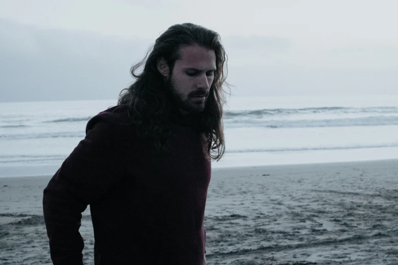 a man standing on top of a beach next to the ocean