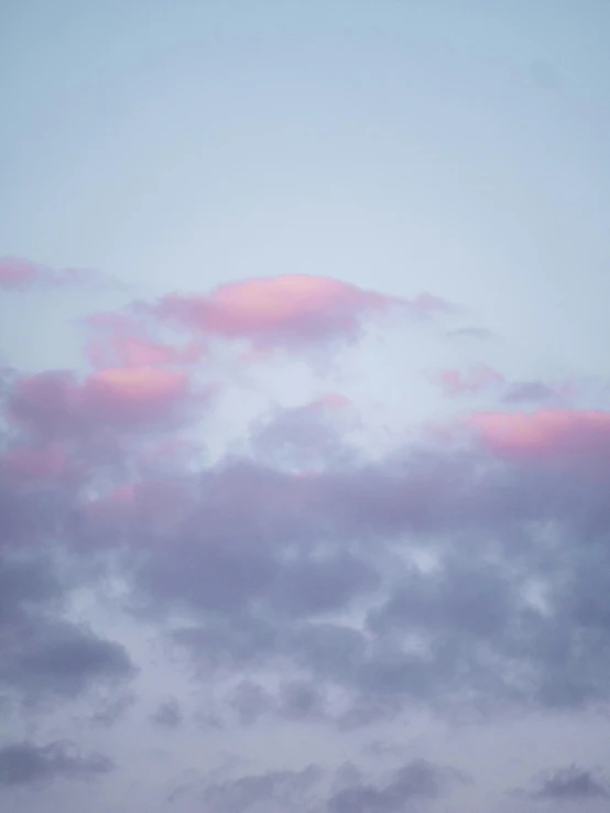 several airplanes fly in the cloudy sky with pink clouds