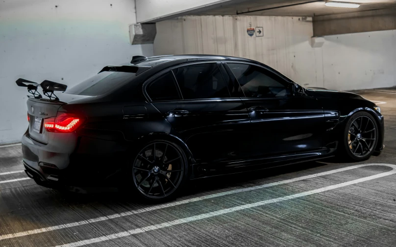 a black bmw is sitting in an underground car wash