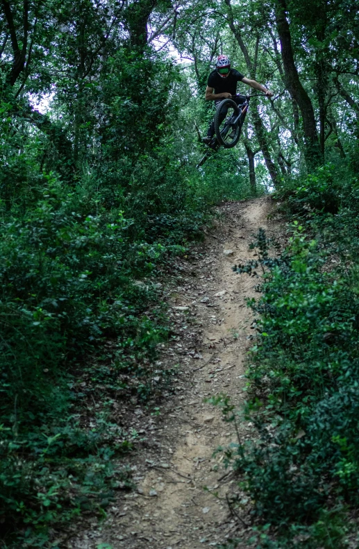 a man riding a bike on top of a dirt road