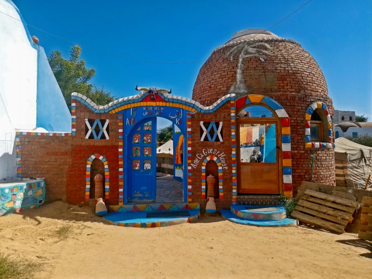 a painted brick structure is sitting on a dirt area