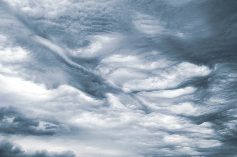 a stormy sky with white clouds and clouds in the distance