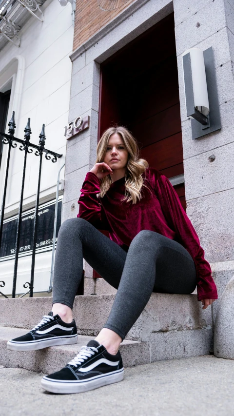 a woman sitting on the steps in front of a building