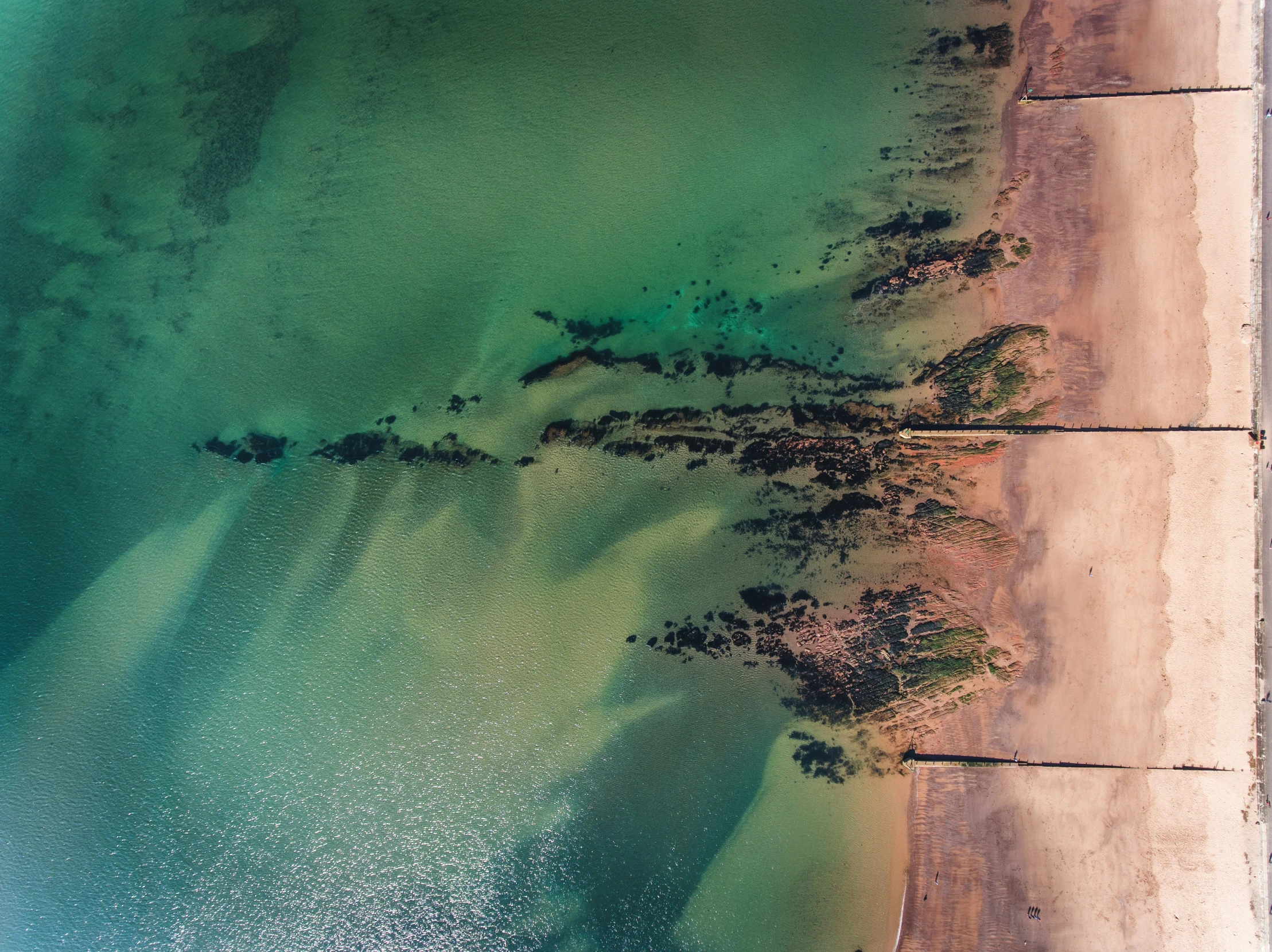 an aerial s of an ocean beach with turquoise waters