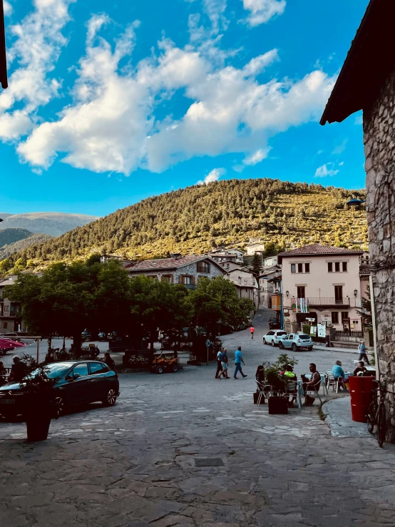 some cars parked in a parking lot by a mountain