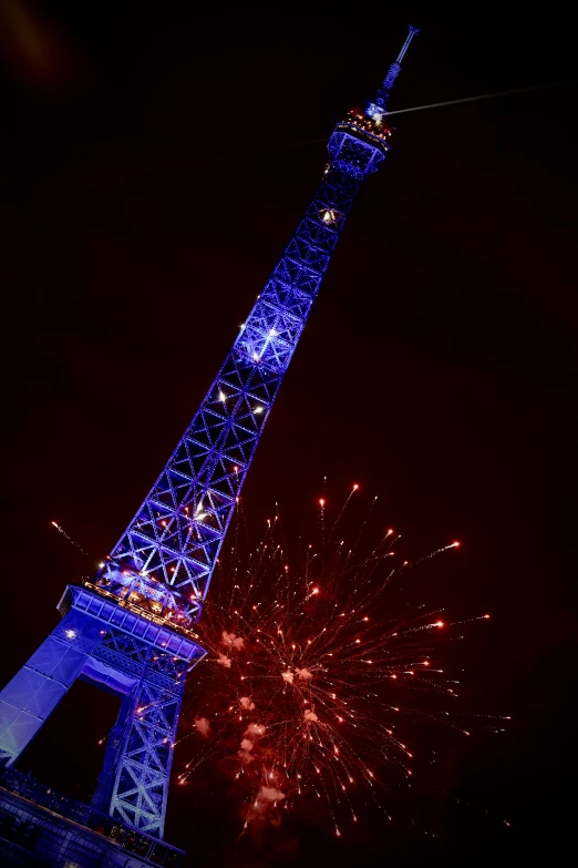 the eiffel tower is lit up with blue lighting