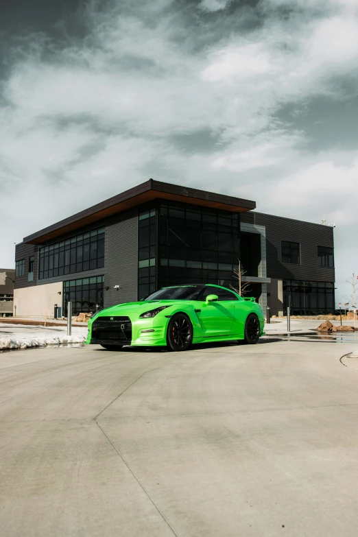 a green car sitting outside of a building